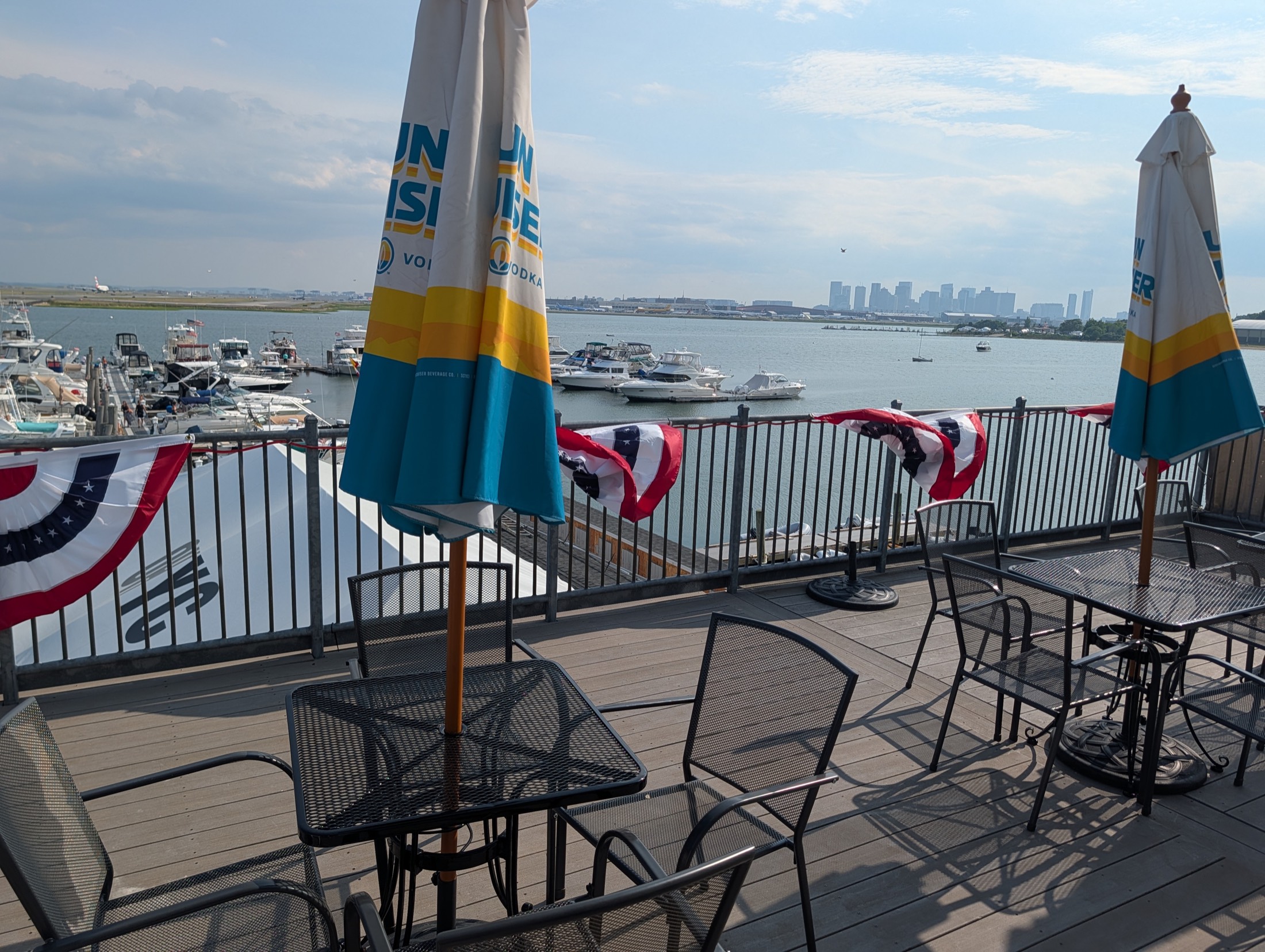 The members' deck — Boston skyline and the marina beyond the rail
